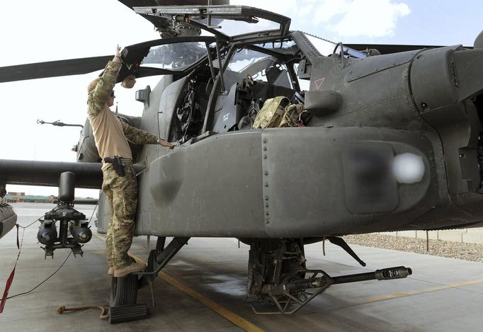 Britain's Prince Harry looks into the cockpit of an Apache helicopter in Camp Bastion, southern Afghanistan in this photograph taken October 31, 2012, and released January 21, 2013. The Prince, who is serving as a pilot/gunner with 662 Squadron Army Air Corps, is on a posting to Afghanistan that runs from September 2012 to January 2013. Photograph taken October 31, 2012. Photograph pixelated at source. REUTERS/John Stillwell/Pool (AFGHANISTAN - Tags: MILITARY POLITICS SOCIETY ROYALS CONFLICT) Published: Led. 21, 2013, 7:45 odp.