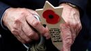 WWII D-Day veteran Mervyn Kersh from Britain holds a remembrance cross as he attends a ceremony at Normandy American Cemetery and Memorial situated above Omaha Beach