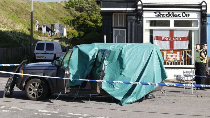 Policisté hlídkují u vozu Land Rover, který se stal terčem šíleného střelce ve městě Seascale na severu Anglie.