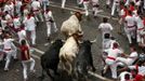 Runners sprint alongside Dolores Aguirre fighting bulls on Santo Domingo hill during the first running of the bulls of the San Fermin festival in Pamplona July 7, 2012. A runner was gored in the leg during the run that lasted two minutes and fifty three seconds, according to local media. REUTERS/Susana Vera (SPAIN - Tags: ANIMALS SOCIETY) Published: Čec. 7, 2012, 7:08 dop.