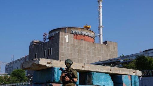 Ruský voják před Záporožskou jadernou elektrárnou.
