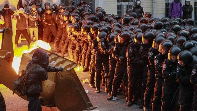 Demonstranti se snaží prorazit policejní bariéru v Kyjevě.