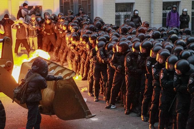 Demonstranti se snaží prorazit policejní bariéru v Kyjevě.