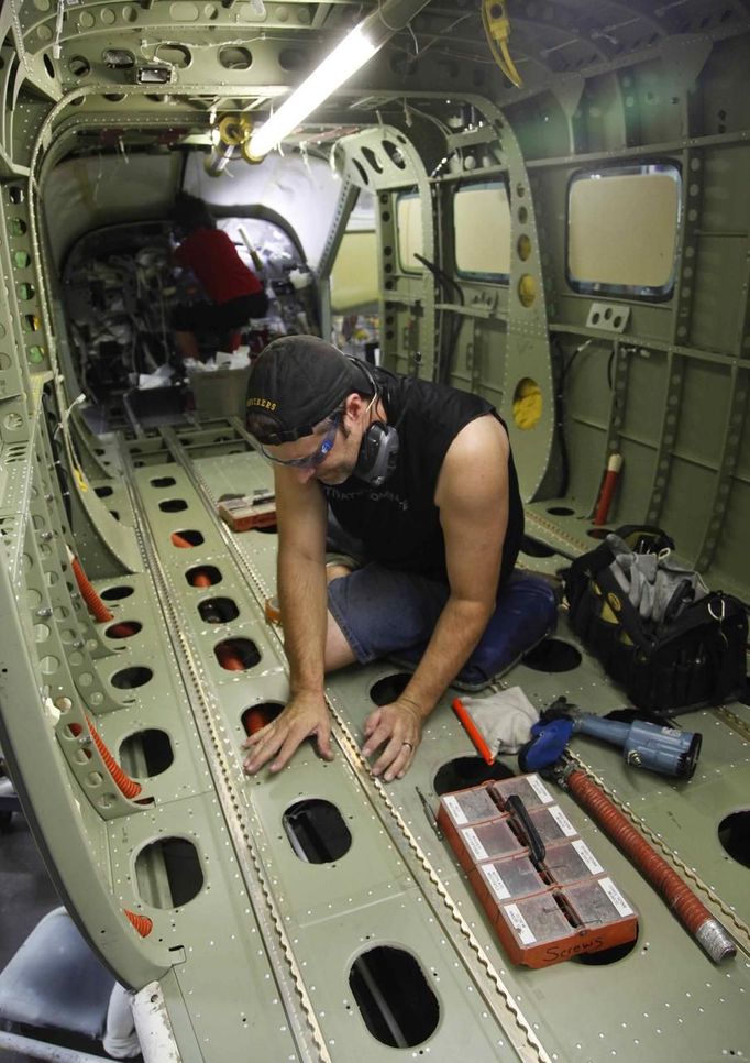 Aaron Haskins works the floor of a business jet during a tour of the Cessna business jet assembly line at their manufacturing plant in Wichita, Kansas August 12, 2012. One of Cessna Aircraft Company CEO and president Scott Ernes' first moves after joining in May 2011 was to carve Cessna up into five units, each of which run by an executive who was responsible for whether the unit reported a profit or loss. Picture taken August 14, 2012. REUTERS/Jeff Tuttle (UNITED STATES - Tags: TRANSPORT BUSINESS) Published: Srp. 22, 2012, 11:39 dop.