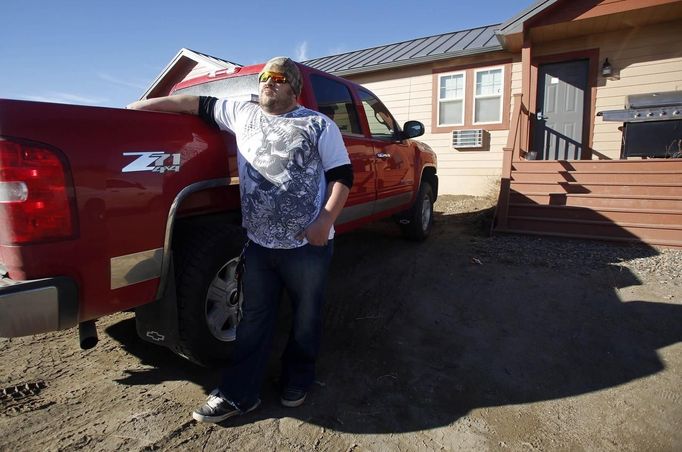 Oil industry worker Chris Skinner stands in front of his accommodations at a so-called man camp outside Watford, North Dakota, October 20, 2012. Thousands of people have flooded into North Dakota to work in state's oil drilling boom. Picture taken October 20, 2012. REUTERS/Jim Urquhart (UNITED STATES - Tags: ENERGY BUSINESS EMPLOYMENT) Published: Říj. 22, 2012, 1:41 odp.