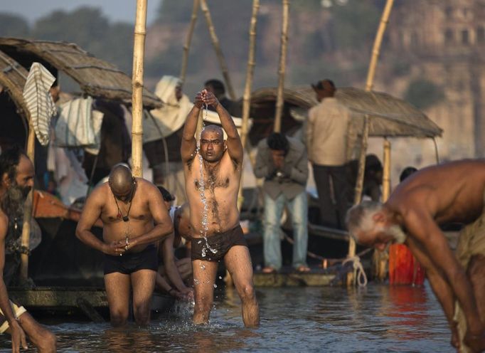 Hindu devotees pray as they take a holy dip in the waters of the Ganges river ahead of the "Kumbh Mela", or Pitcher Festival, in the northern Indian city of Allahabad January 10, 2013. During the festival, hundreds of thousands of Hindus take part in a religious gathering at the banks of the river Ganges. The festival is held every 12 years in different Indian cities. REUTERS/Ahmad Masood (INDIA - Tags: RELIGION SOCIETY) Published: Led. 10, 2013, 8:37 dop.