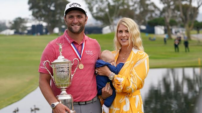 Jon Rahm pózuje s trofejí pro vítěze US Open, manželkou a synem.