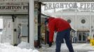 A worker clears snow from the area in front of Brighton Pier in Brighton, southern England March 12, 2013. Southern England was hit with heavy snow overnight. REUTERS/Luke MacGregor (BRITAIN - Tags: ENVIRONMENT SOCIETY) Published: Bře. 12, 2013, 1:16 odp.