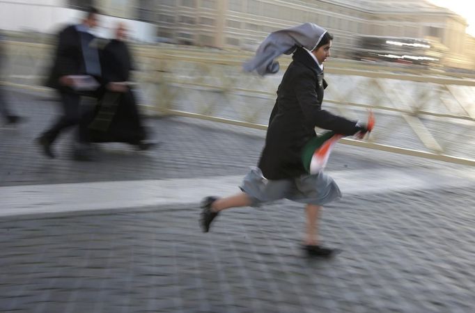 A nun runs in Saint Peter's Square to take a good vantage point before the inaugural mass for Pope Francis at the Vatican, March 19, 2013. Pope Francis celebrates his inaugural mass on Tuesday among political and religious leaders from around the world and amid a wave of hope for a renewal of the scandal-plagued Roman Catholic Church. REUTERS/Max Rossi (VATICAN - Tags: RELIGION POLITICS) Published: Bře. 19, 2013, 7:41 dop.