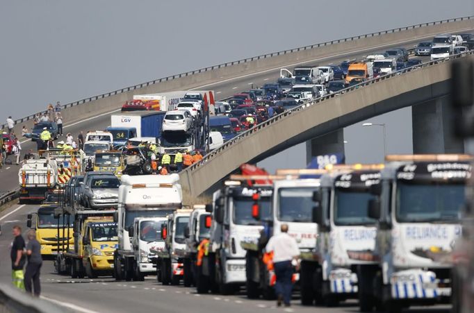 Recovery trucks line up to collect over 100 vehicles involved in multiple collisions, which took place in dense fog during the morning rush hour, on the Sheppey Bridge in Kent, east of London, September 5, 2013. Eight people were seriously injured and dozens hurt in the multiple crashes.