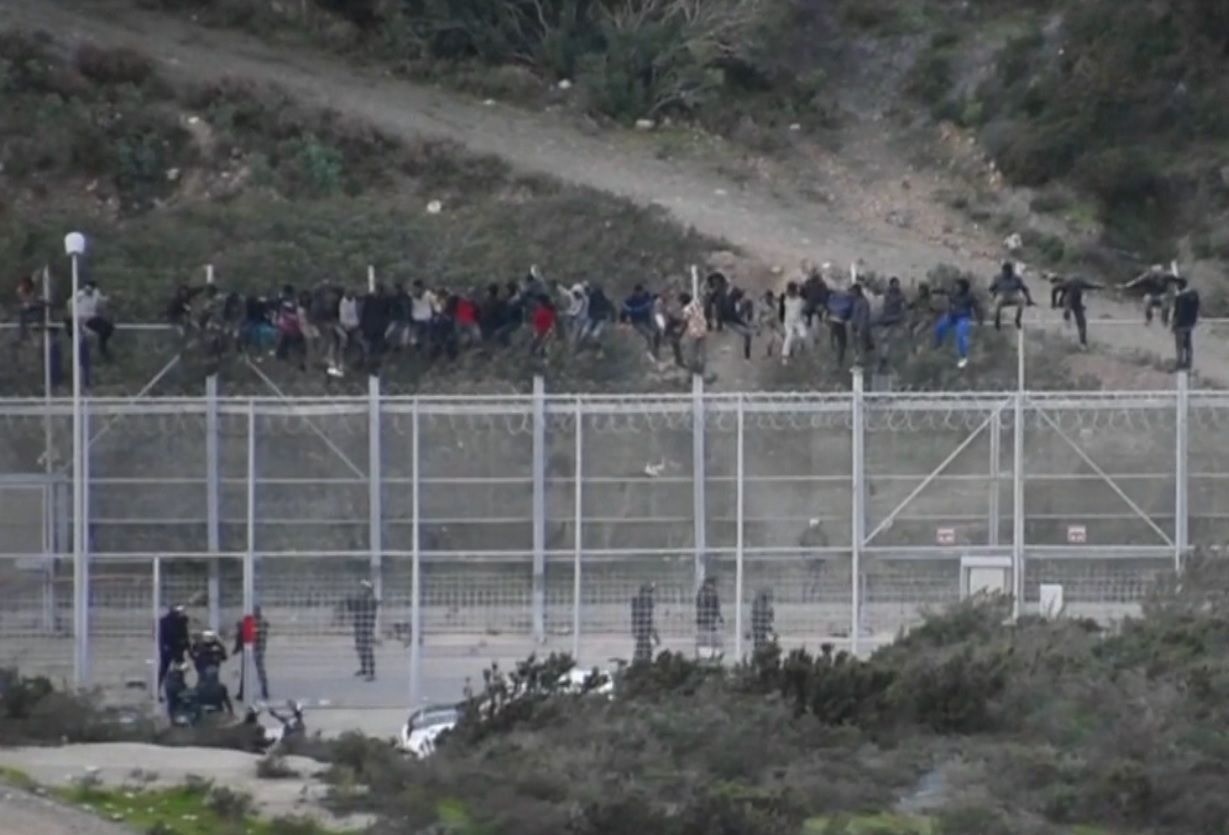 Migranti se pokoušejí překonat plot mezi Marokem a Ceutou