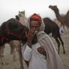 A camel herder kisses the nose of one of his camels as he waits for customers at Pushkar Fair in the desert Indian state of Rajasthan November 23, 2012. Many international and domestic tourists throng to Pushkar to witness one of the most colourful and popular fairs in India. Thousands of animals, mainly camels, are brought to the fair to be sold and traded. REUTERS/Danish Siddiqui (INDIA - Tags: SOCIETY ANIMALS) Published: Lis. 23, 2012, 8:08 dop.