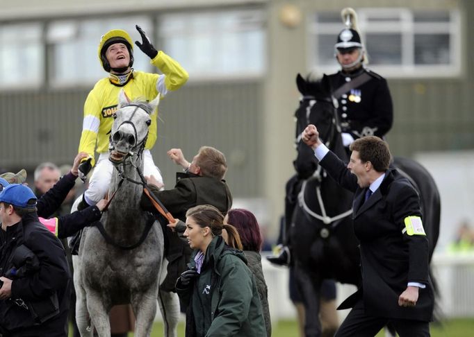 Žokej Daryl Jacob na bělouši Neptune Collonges se raduje z vítězství ve Velké národní na závodišti Aintree u Liverpoolu.