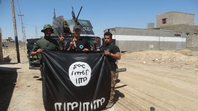Iráčtí vojáci s ukořistěnou vlajkou Islámského státu v provincii Anbar. Ilustrační foto.