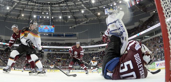 Germany's Marcel Noebels (L) scores past Latvia's goalie Kristers Gudlevskis (R) during the first period of their men's ice hockey World Championship group B game at Mins