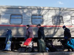 Evakuovaní Ukrajinci se shromažďují na železniční stanici předtím než nastoupí do vlaku a opustí město Doněck.