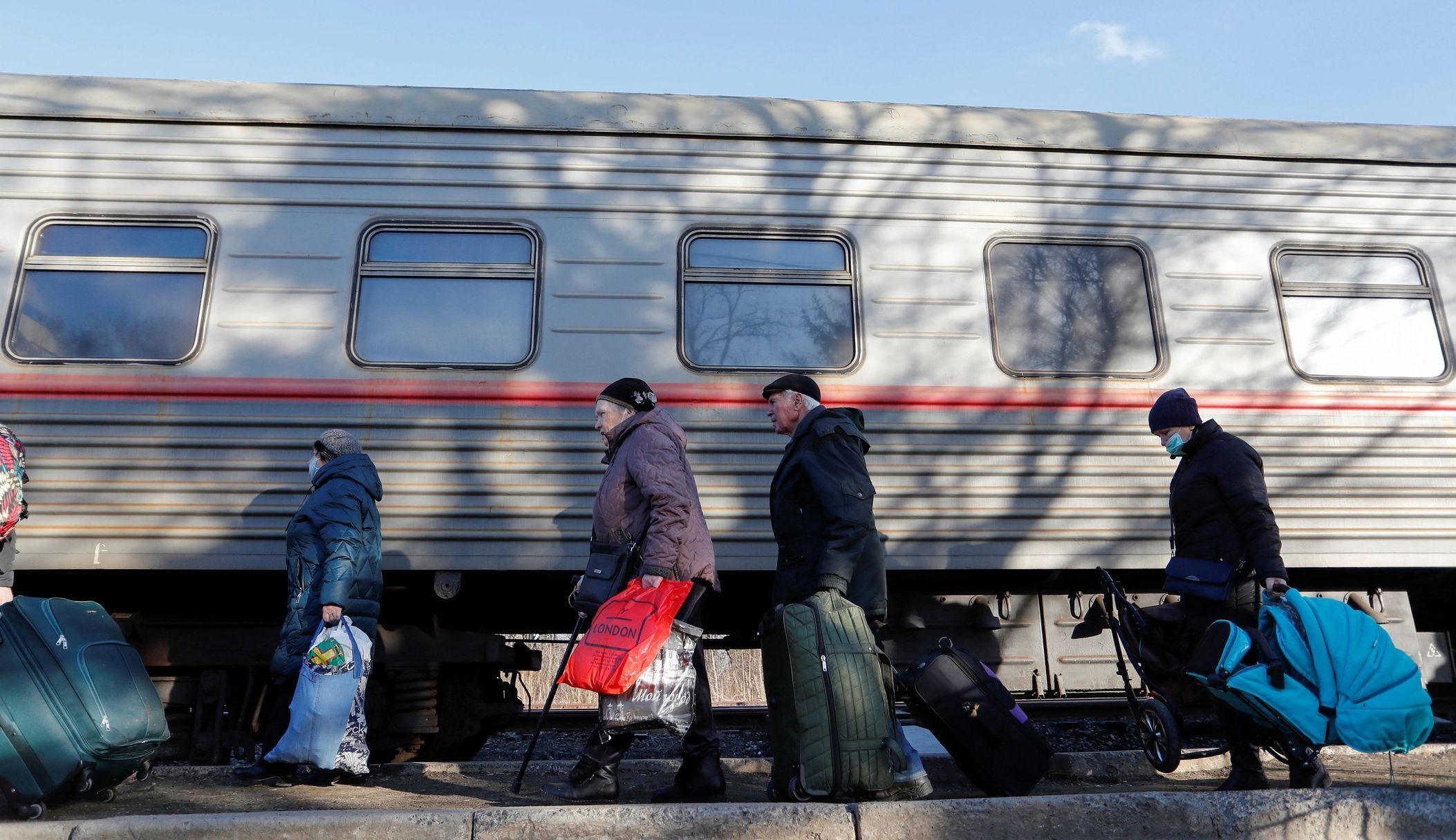 Evakuovaní Ukrajinci se shromažďují na železniční stanici předtím než nastoupí do vlaku a opustí město Doněck.