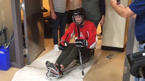 Kapitán týmu Edmonton Oilers Connor McDavid se chystá na led na speciálních saních určených na sledge hokej.
