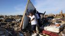 Men lift a wall in an effort to salvage belongings from their tornado-ravaged homes in Moore, Oklahoma May 21, 2013. Rescuers went building to building in search of victims and thousands of survivors were homeless on Tuesday after a massive tornado tore through the Oklahoma City suburb of Moore, wiping out whole blocks of homes and killing at least 24 people. REUTERS/Rick Wilking (UNITED STATES - Tags: DISASTER ENVIRONMENT) Published: Kvě. 22, 2013, 1:38 dop.