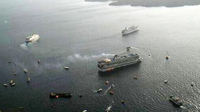Pohled z vrtulníku na ztroskotanou loď a záchranné čluny.