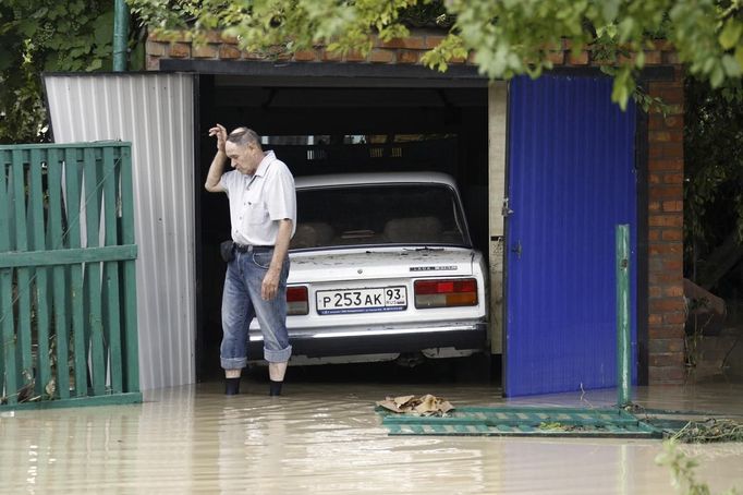 A local resident walks through a flooded street in the village of Novoukrainsk, near the southern Russian town of Krymsk, July 7, 2012. At least 99 people were killed in floods and landslides in southern Russia after two months' average rainfall fell in a few hours overnight, police and emergency officials said on Saturday. REUTERS/Vladimir Anosov (RUSSIA - Tags: DISASTER ENVIRONMENT) Published: Čec. 7, 2012, 3:42 odp.