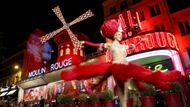 Paříž, Francie: tanečnice kankánu před Moulin Rouge, dnes se slavné červené lopatky znovu roztáčí v rytmu města.