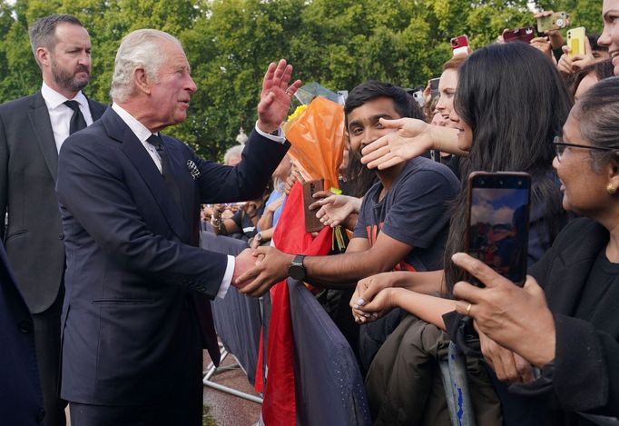 Nový britský král Karel III. se zdraví s lidmi před Buckinghamským palácem.