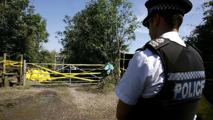 A police officer stands in front of a closed foothpath and a gate displaying a foot and mouth disease warning, in Flexford, near Guildford, southern England August 5, 2007. A U.S.-French pharmaceutical company was at the heart of an investigation by British authorities on Sunday to try to find the source of an outbreak of highly infectious foot and mouth disease. REUTERS/Alessia Pierdomenico (BRITAIN)