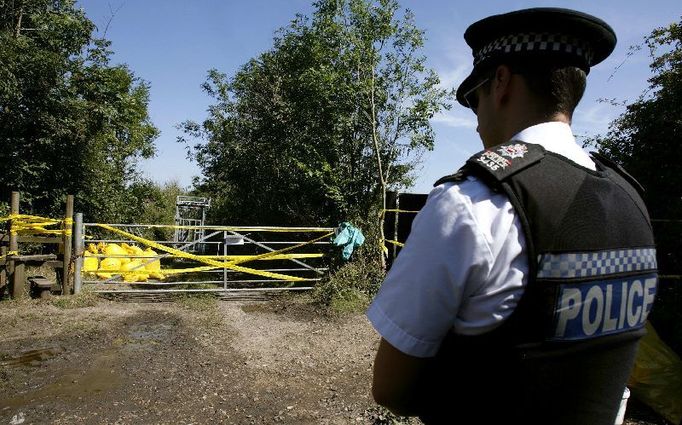 A police officer stands in front of a closed foothpath and a gate displaying a foot and mouth disease warning, in Flexford, near Guildford, southern England August 5, 2007. A U.S.-French pharmaceutical company was at the heart of an investigation by British authorities on Sunday to try to find the source of an outbreak of highly infectious foot and mouth disease. REUTERS/Alessia Pierdomenico (BRITAIN)