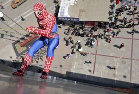 Muž v kostýmu Spider-Mana slaňuje z budovy při propagaci čínské premiéry filmu Spider-Man 3