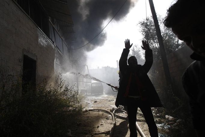 Firefighters try to extinguish a fire at a factory, which according to Palestinians was hit by an Israeli air strike in Gaza November 16, 2012. Egyptian Prime Minister Hisham Kandil, on a brief visit to the Gaza Strip on Friday, denounced Israel's attacks on the Palestinian territory and said Cairo would try to secure a ceasefire. Fighting continued along the Israel-Gaza border during Kandil's three-hour visit. REUTERS/Ahmed Zakot (GAZA - Tags: CIVIL UNREST MILITARY POLITICS) Published: Lis. 16, 2012, 9:27 dop.