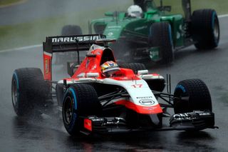 Marussia Formula One driver Jules Bianchi of France drives in front of Caterham Formula One driver Kamui Kobayashi of Japan during the Japanese F1 Grand Prix at the Suzuk