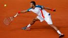 Francouzský tenista Jo-Wilfried Tsonga bekendem odráží míček zpět na Srba Novaka Djokoviče během čtvrtfinále French Open 2012.