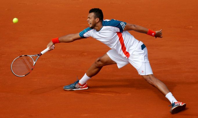 Francouzský tenista Jo-Wilfried Tsonga bekendem odráží míček zpět na Srba Novaka Djokoviče během čtvrtfinále French Open 2012.