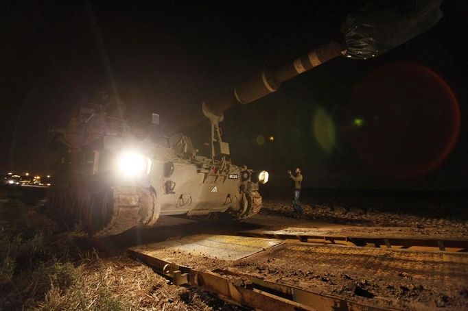 An Israeli helps off-load a 155mm mobile cannon after it was transported to an area just outside the northern Gaza Strip November 15, 2012. Israeli aircraft attacked targets throughout the Gaza Strip on Thursday night, unleashing more than 25 strikes in swift succession according to Reuters witnesses. REUTERS/Amir Cohen (ISRAEL - Tags: POLITICS CIVIL UNREST) Published: Lis. 15, 2012, 7:56 odp.