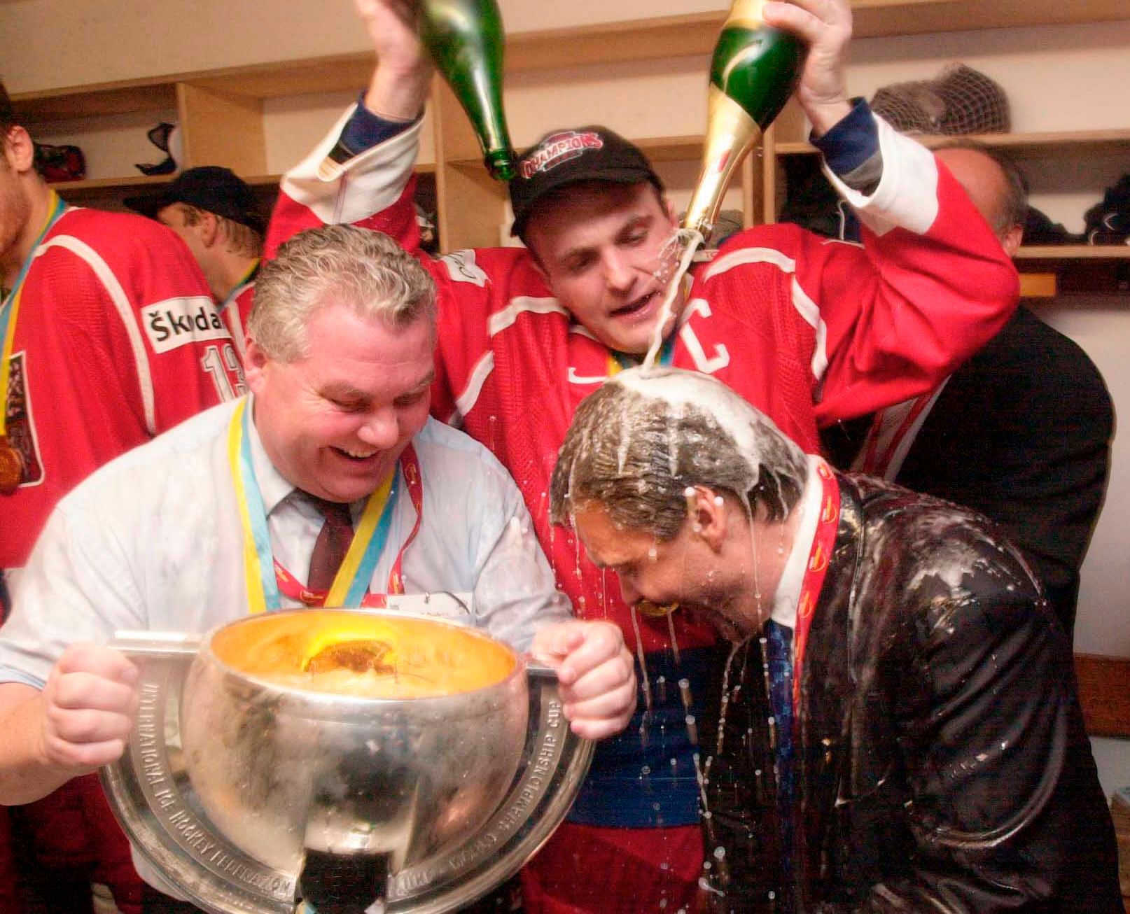 Oslavy titulu na MS 2001: Robert Reichel kropí šampaňským Reného Fasela, přihlíží František Černík