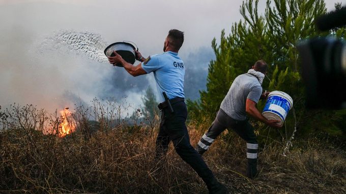 Místní pomáhají s hašením požáru v portugalském městě Cascais.