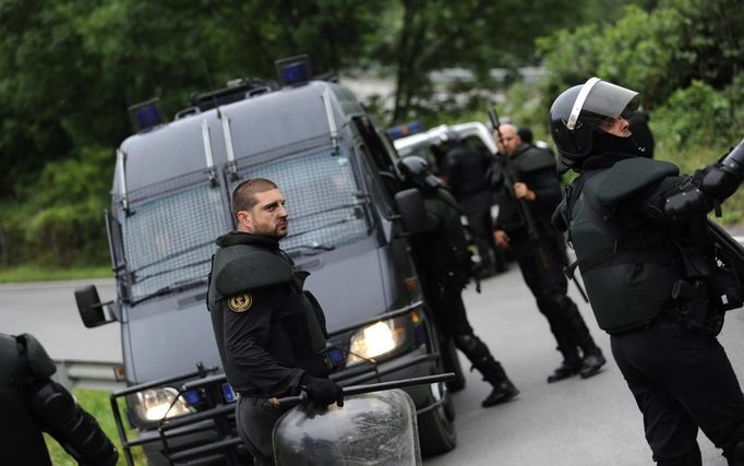 Riot police officers stand in the A-66 motorway after it was blocked by miners during a demonstration in La Cobertoria, near Oviedo, northern Spain June 20, 2012. The miners were protesting against the government's proposal to decrease funding for coal production. REUTERS/Eloy Alonso (SPAIN - Tags: CIVIL UNREST POLITICS BUSINESS EMPLOYMENT) Published: Čer. 20, 2012, 1:35 odp.