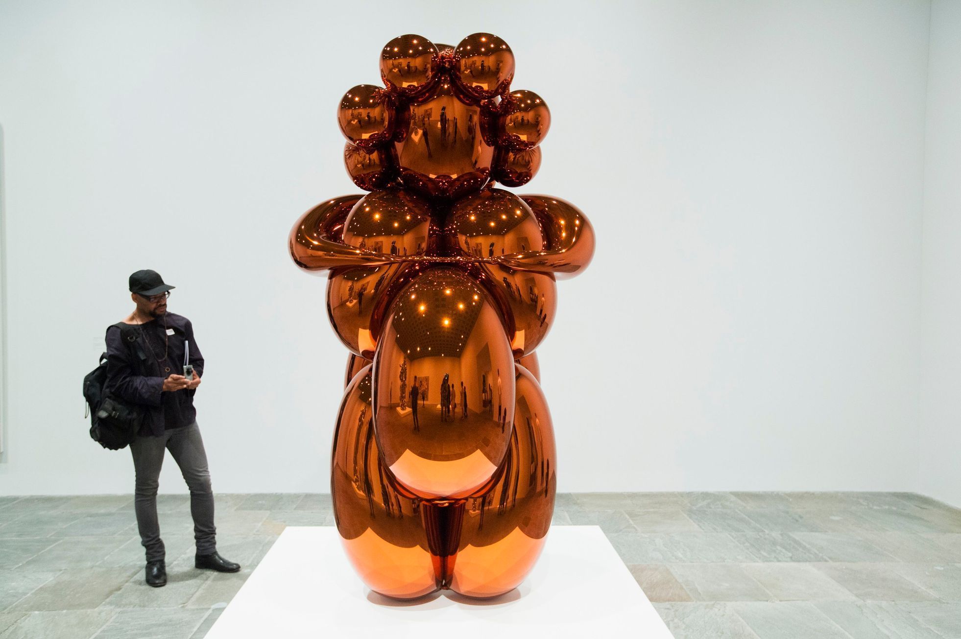 A man looks at a sculpture before the opening of a Jeff Koons retrospective at the Whitney Museum of American Art in New York