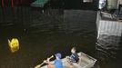 Volunteers Branson Skierski (L) and Carter Chancey, both 14, look for items to salvage as they move their boat through a flooded Melody Christian Academy in Live Oak, Florida, June 27, 2012. Tropical Storm Debby weakened to a tropical depression after it drifted ashore on Florida's Gulf Coast, even as it dumped more rain on flooded areas and sent thousands of people fleeing from rising rivers. REUTERS/Phil Sears (UNITED STATES - Tags: ENVIRONMENT DISASTER) Published: Čer. 28, 2012, 2:46 dop.