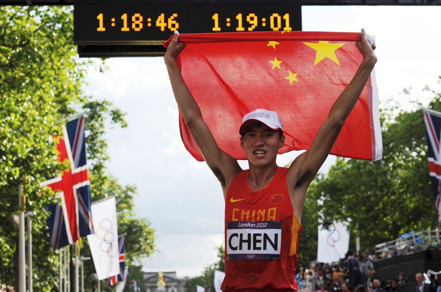 Čínský chodec Ding Čen slaví vítězství v závodu na 20 kilometrů na OH 2012 v Londýně.