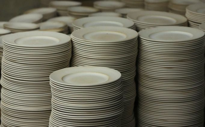 Stacks of partially fired plates wait to be checked in the "biscuit room" at the Middleport pottery in Stoke-on-Trent, central England January 22, 2013. The pottery which dates back to 1888 and was rescued from closure in 2009, continues to use traditional methods to produce its range of ceramics and famous Burleigh Ware pottery. REUTERS/Phil Noble (BRITAIN - Tags: BUSINESS EMPLOYMENT SOCIETY) Published: Led. 22, 2013, 5:30 odp.