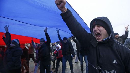 Demonstrace pod obří ruskou vlajkou v Simferopolu na Krymu.