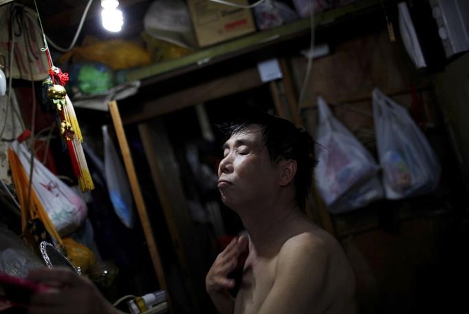 Xiao Cao, a 57-year-old gay man, prepares to dress after taking a shower at his home in Shanghai April 8, 2012. China's gay community has long been on the edges of society but it is gradually becoming more accepted. Cao, who is an unemployed drag queen, is one whose life lifts the curtain on a less romanticised view of Chinese homosexuals. Living in an eight square metres apartment behind a public toilet and with a monthly income of 500 yuan ($79) from social insurance, he passes his days dancing in public and spending time with friends at gay clubs. Picture taken April 8, 2012. REUTERS/Aly Song (CHINA - Tags: SOCIETY) CHINA OUT. NO COMMERCIAL OR EDITORIAL SALES IN CHINA. ATTENTION EDITORS PICTURE 03 OF 28 OF PACKAGE 'GAY AND OUT IN CHINA' TO FIND ALL IMAGES SEARCH 'GAY OUT CHINA' Published: Čer. 1, 2012, 12:33 dop.