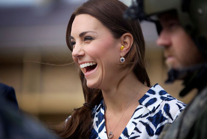 Catherine, Duchess of Cambridge, laughs as she puts on earplugs as they prepare to board a Royal Australian Navy MRH90 helicopter at Sydney's Victoria Barracks