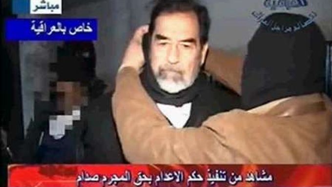 Kat navléká Saddámovi oprátku. 30.prosince 2006 byl bývalý irácký prezident popraven.
