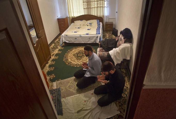 Anzor and Salakhutdin, students at the Russian Islamic University, pray in their flat in the Chechen capital Grozny April 23, 2013. The naming of two Chechens, Dzhokhar and Tamerlan Tsarnaev, as suspects in the Boston Marathon bombings has put Chechnya - the former site of a bloody separatist insurgency - back on the world's front pages. Chechnya appears almost miraculously reborn. The streets have been rebuilt. Walls riddled with bullet holes are long gone. New high rise buildings soar into the sky. Spotless playgrounds are packed with children. A giant marble mosque glimmers in the night. Yet, scratch the surface and the miracle is less impressive than it seems. Behind closed doors, people speak of a warped and oppressive place, run by a Kremlin-imposed leader through fear. Picture taken April 23, 2013. REUTERS/Maxim Shemetov (RUSSIA - Tags: SOCIETY POLITICS RELIGION EDUCATION) ATTENTION EDITORS: PICTURE 31 OF 40 FOR PACKAGE 'INSIDE MODERN CHECHNYA'. SEARCH 'REBUILDING CHECHNYA' FOR ALL IMAGES Published: Kvě. 1, 2013, 8:15 dop.