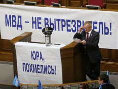 Opoziční poslanci ze Strany regionů rozvěsili v ukrajinském parlamentu transparenty s nápisy "Ministerstvo vnitra není záchytka" či "Juro, vystřízlivěj!"