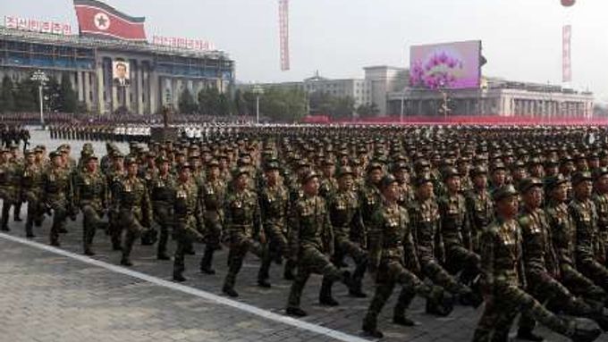 Severokorejští vojáci hledí na své vůdce.