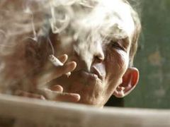 Indonéský státní zaměstnanec si v Jakartě užívá chvilku klidu s novinami a cigaretou